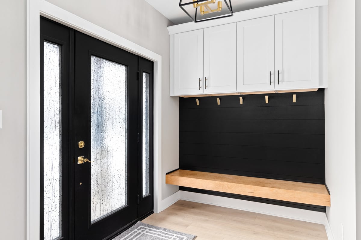 Custom mudroom storage with built-in cubbies and gold hardware