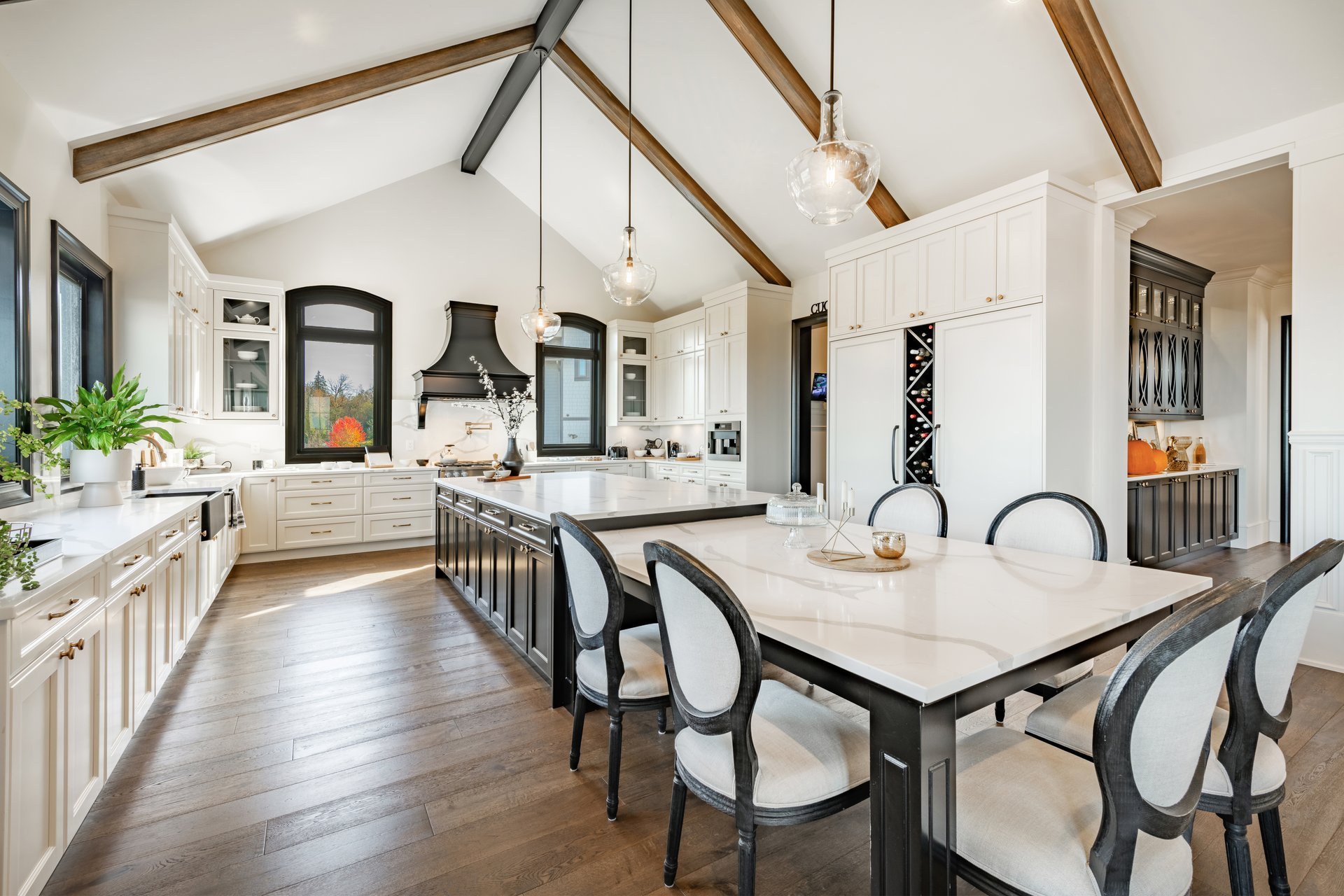 Luxury modern farmhouse kitchen with custom wood cabinetry, marble island, and vaulted ceilings