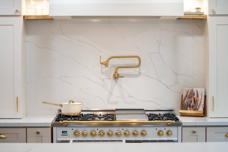 Bright modern kitchen with cream cabinetry and marble backsplash